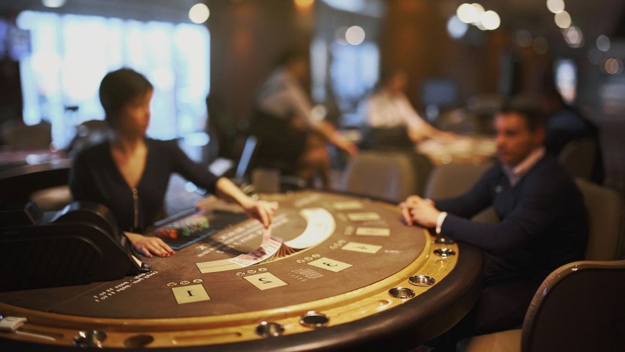 Blackjack table with host dealing cards