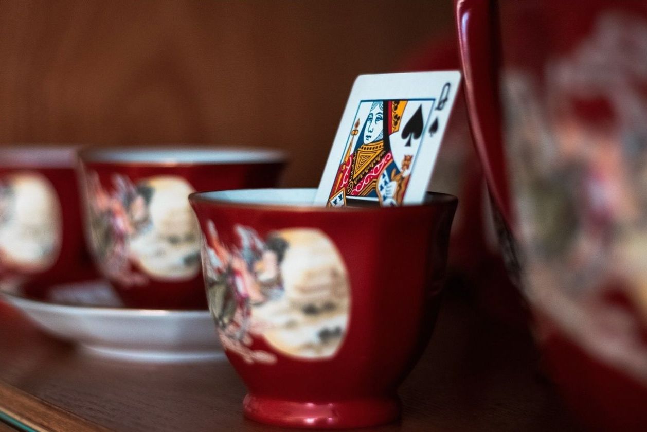 Detail styling — a queen card in a porcelain cup